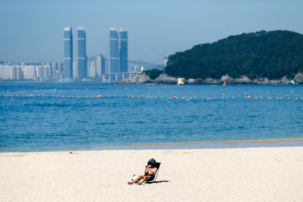 2023年8月3日，市民在韩国釜山的沙滩晒日光浴。新华社记者王益亮摄
